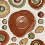 duża czerwona patera serce o obłym kształcie z piegowatej gliny - w zestawie z innymi naczyniami z kolekcji