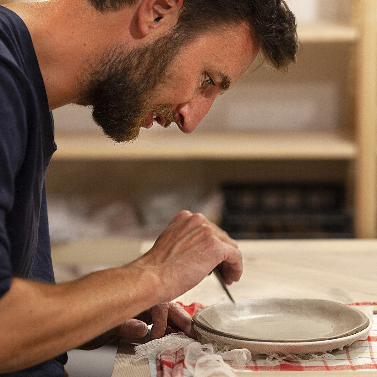 Mężczyzna lepi talerz ceramiczny
