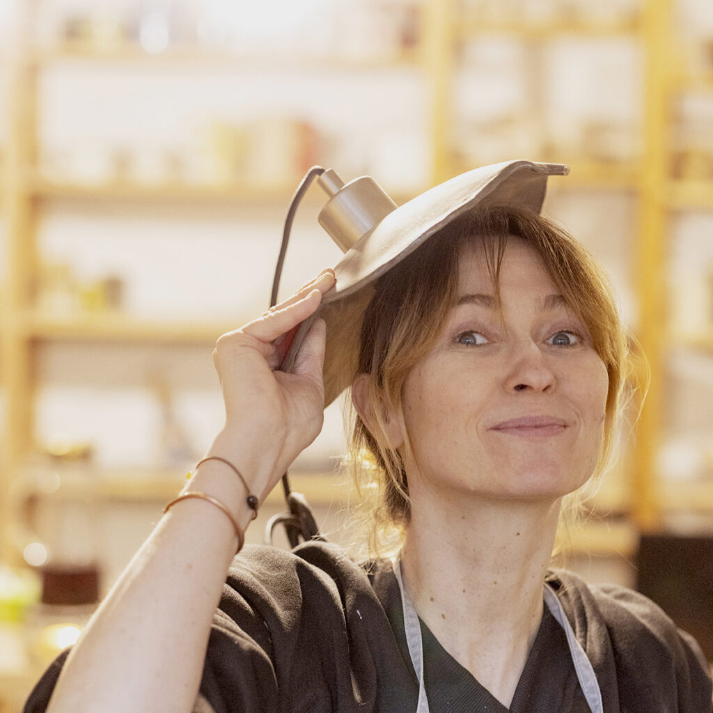 Uśmiechnięta kobieta z lampą ceramiczną.